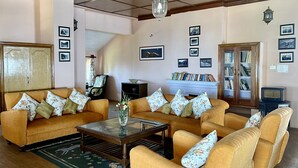 A living room with two sofas, a coffee table, a fireplace, and a bookshelf.