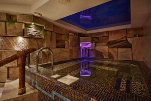 Relax by the pool surrounded by a spa-like ambiance, complete with a mosaic-tiled floor and a wooden handrail.