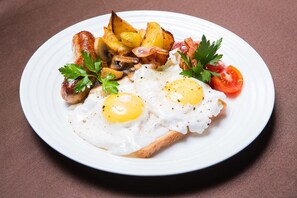 Savor a hearty breakfast with eggs, toast, sautéed mushrooms, roasted potatoes, and fresh tomato.