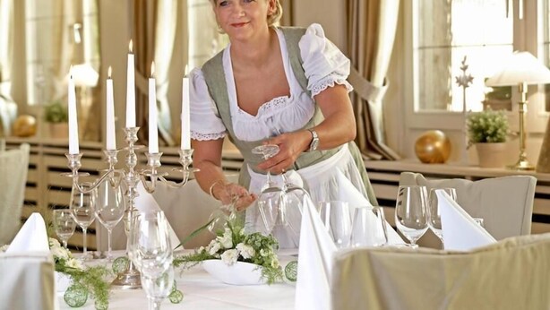 A dining table set with candles, glasses, and a floral centerpiece. - Landgasthof Zum Lamm (Bahlingen)