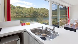 Une cuisine moderne dotée d’un grand évier et offrant une vue sur un lac et des montagnes.