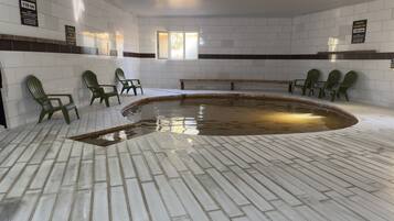 Una piscina interior con paredes de azulejos y bancos.