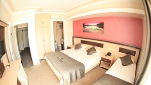 Ett hotellrum med två sängar, ett badrum och en garderob.