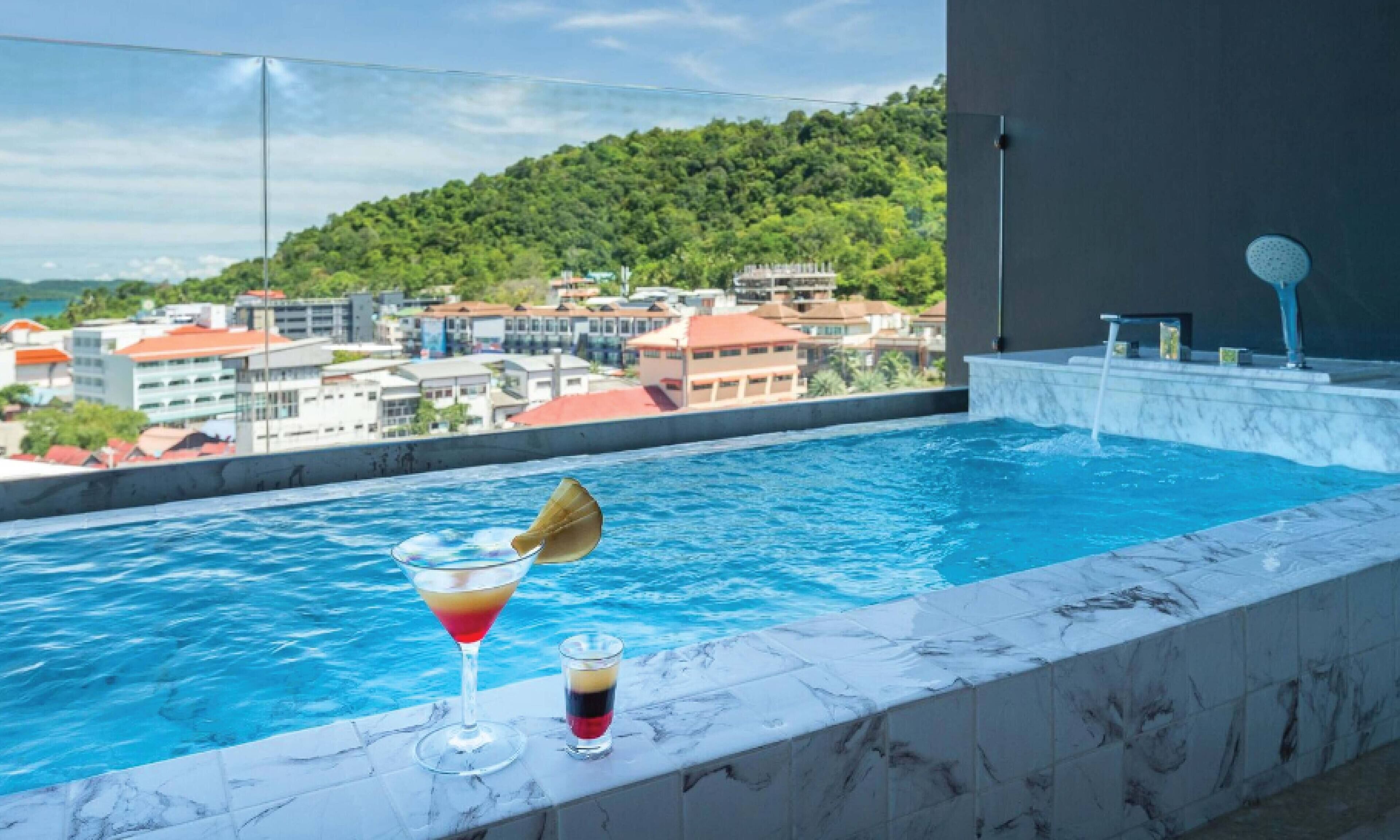 Una piscina en la azotea con vistas despejadas a un pueblo en la colina.