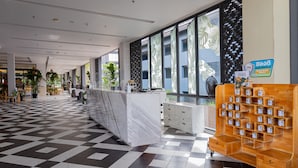 A spacious lobby with a checkered floor, a marble reception desk, and a display of cookies. - Panan Krabi Resort (Krabi)