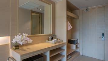 Un baño moderno con tocador de madera, espejo, lavabo y zona de ducha.