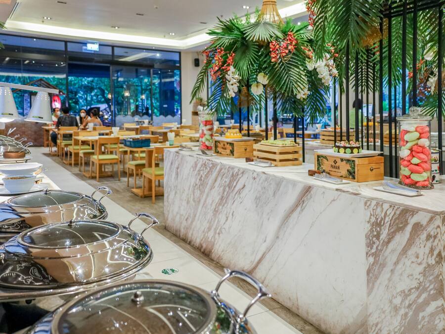 A buffet setup with food containers and a decorative centerpiece.