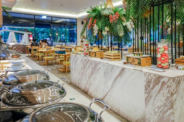 A buffet setup with food containers and a decorative centerpiece. - Panan Krabi Resort (Krabi)