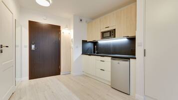 A modern kitchen with wooden cabinets, a built-in microwave, and a dishwasher.