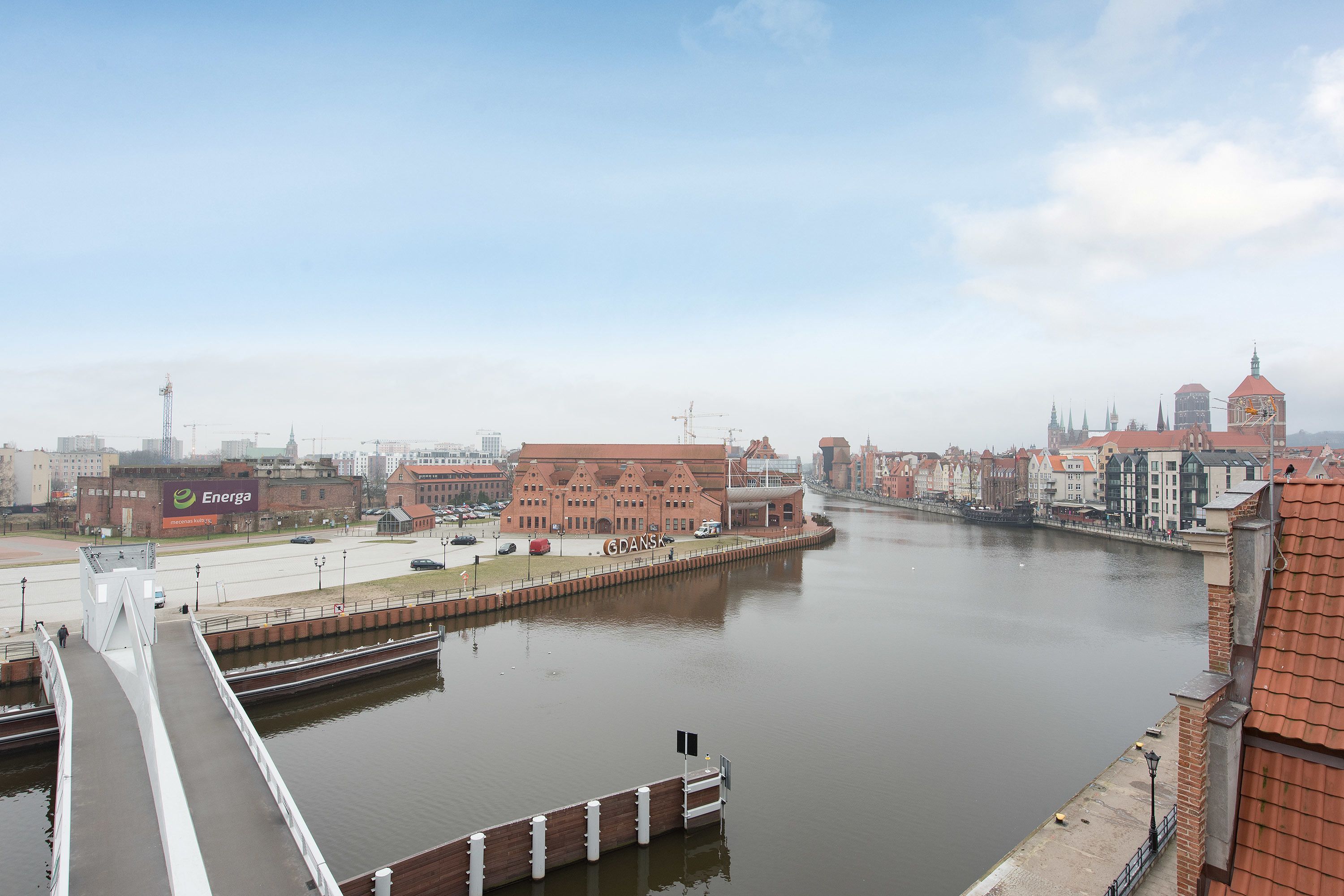 A river with a bridge, buildings, and a sign for 'Energa'.