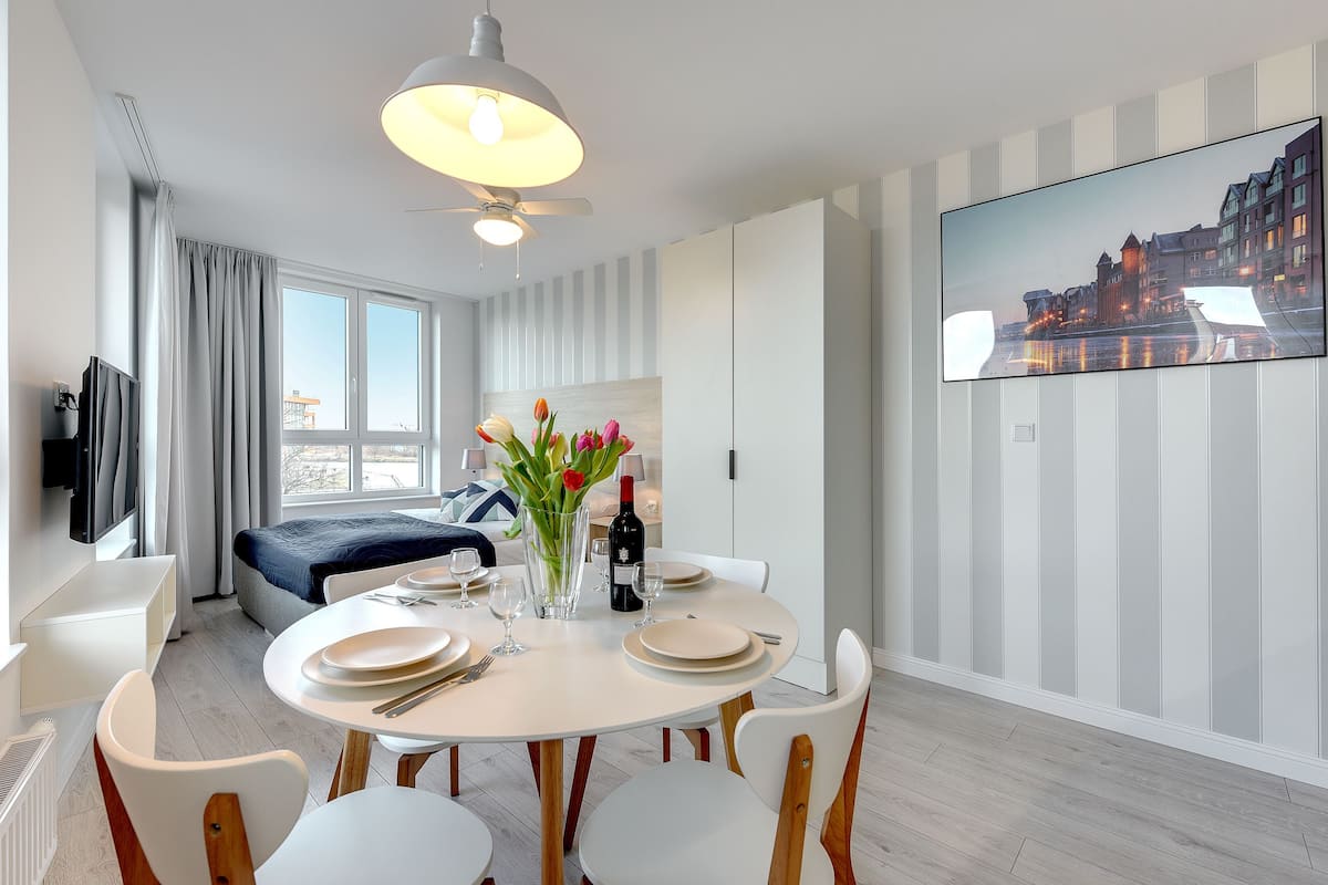 Une chambre d’hôtel moderne dotée d’un coin repas, d’un lit, d’une télévision et offrant une vue sur la ville.