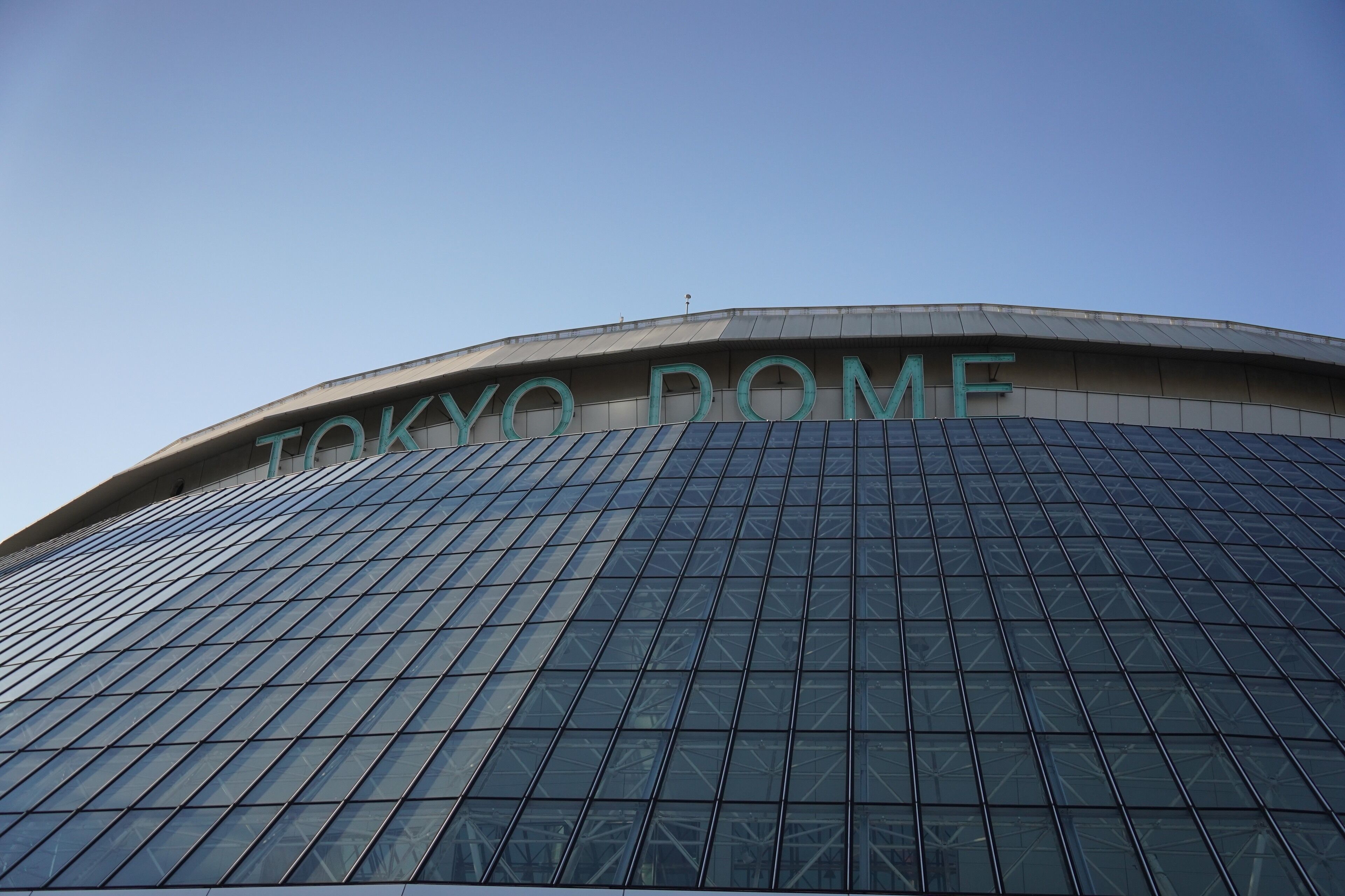Vue extérieure du Tokyo Dome par un ciel dégagé.