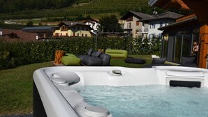 A hot tub with a view of a residential area, including houses and greenery.