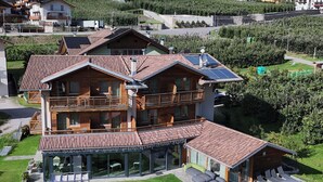 A large wooden house with multiple balconies and a spacious patio area.