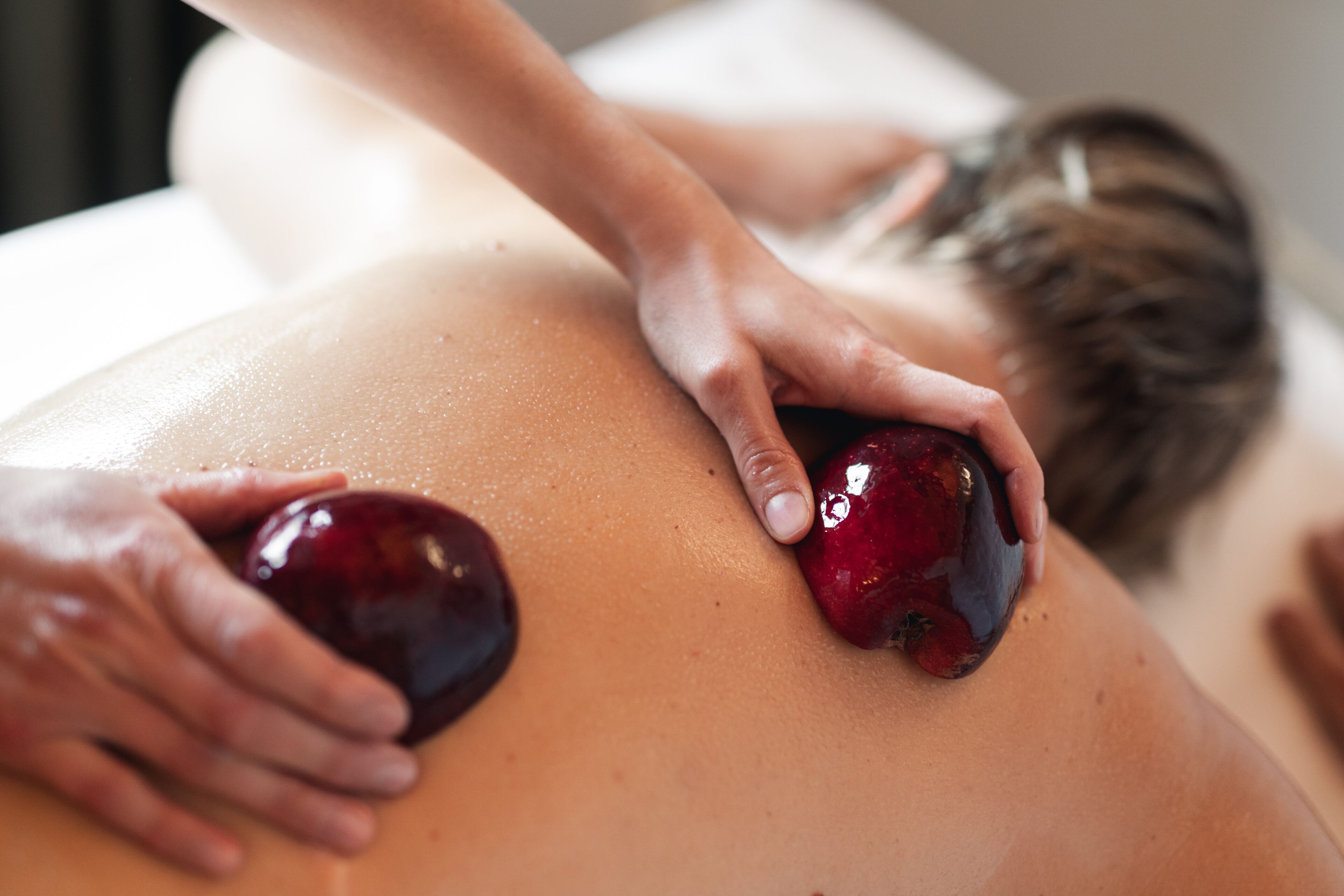 Une séance de massage où la personne est allongée sur le ventre et reçoit un soin du dos.