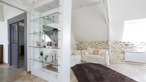 Uma sala moderna com uma estante de vidro, um sofá confortável e uma parede de pedra.