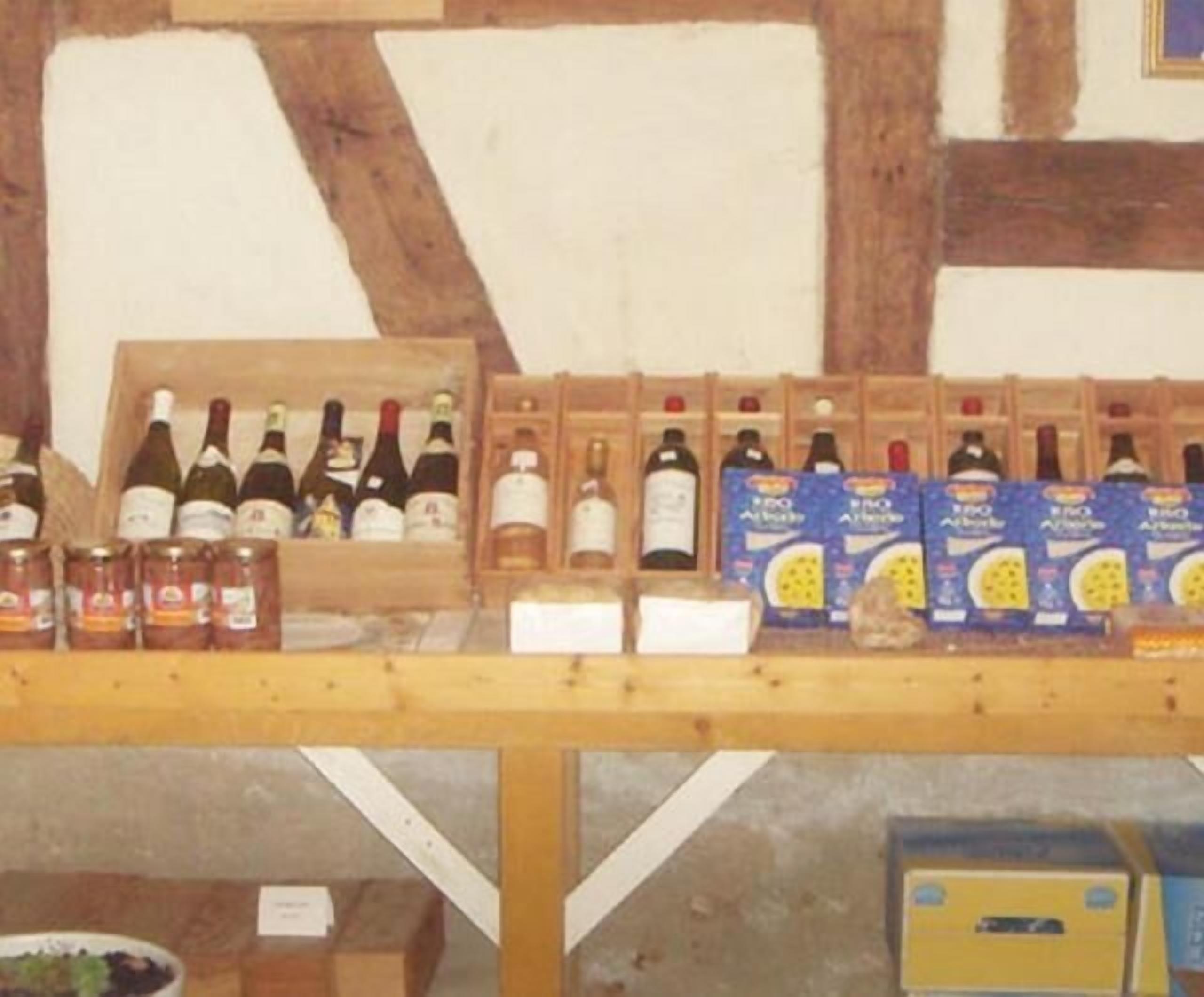 A wooden table with various wine bottles and boxes, likely in a cellar or storage area.