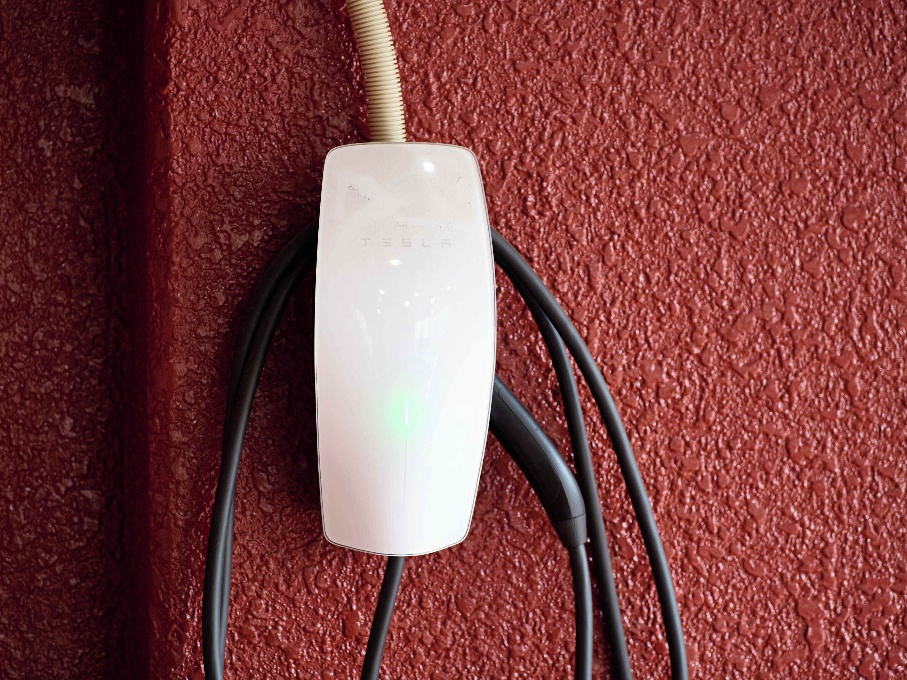 Un enchufe blanco con el nombre de la marca visible, conectado a un cable negro.