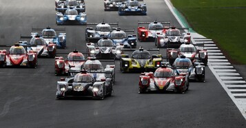 Un evento de carreras con varios autos en una pista.