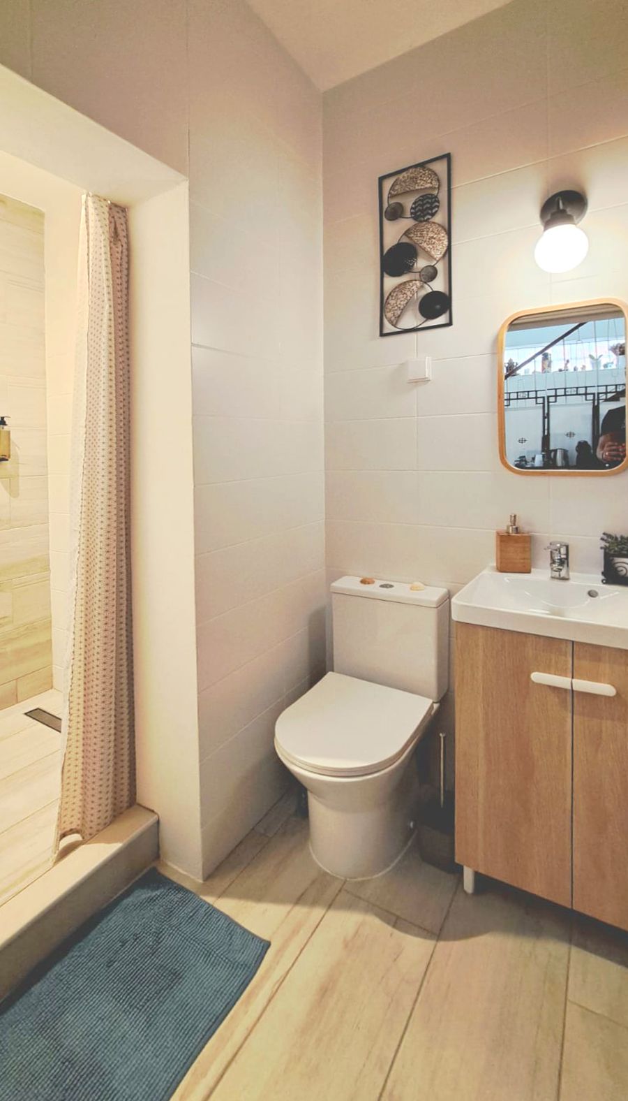 Une salle de bain comprenant des toilettes, un lavabo et un espace douche.