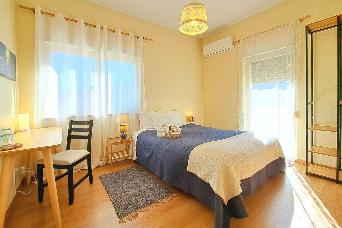 Ein Schlafzimmer mit einem Bett, einem Nachttisch, einem Sessel und einer Lampe.