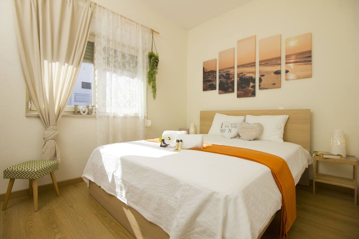 Ein ordentlich eingerichtetes Schlafzimmer mit Bett, Nachttisch und Stuhl.