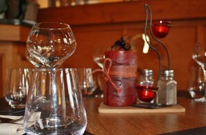 A bar setting with multiple glasses and a candle holder. - Au Cheval Blanc (Saint-Amarin)