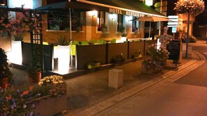 A hotel with a restaurant, outdoor seating, and potted plants. - Au Cheval Blanc (Saint-Amarin)