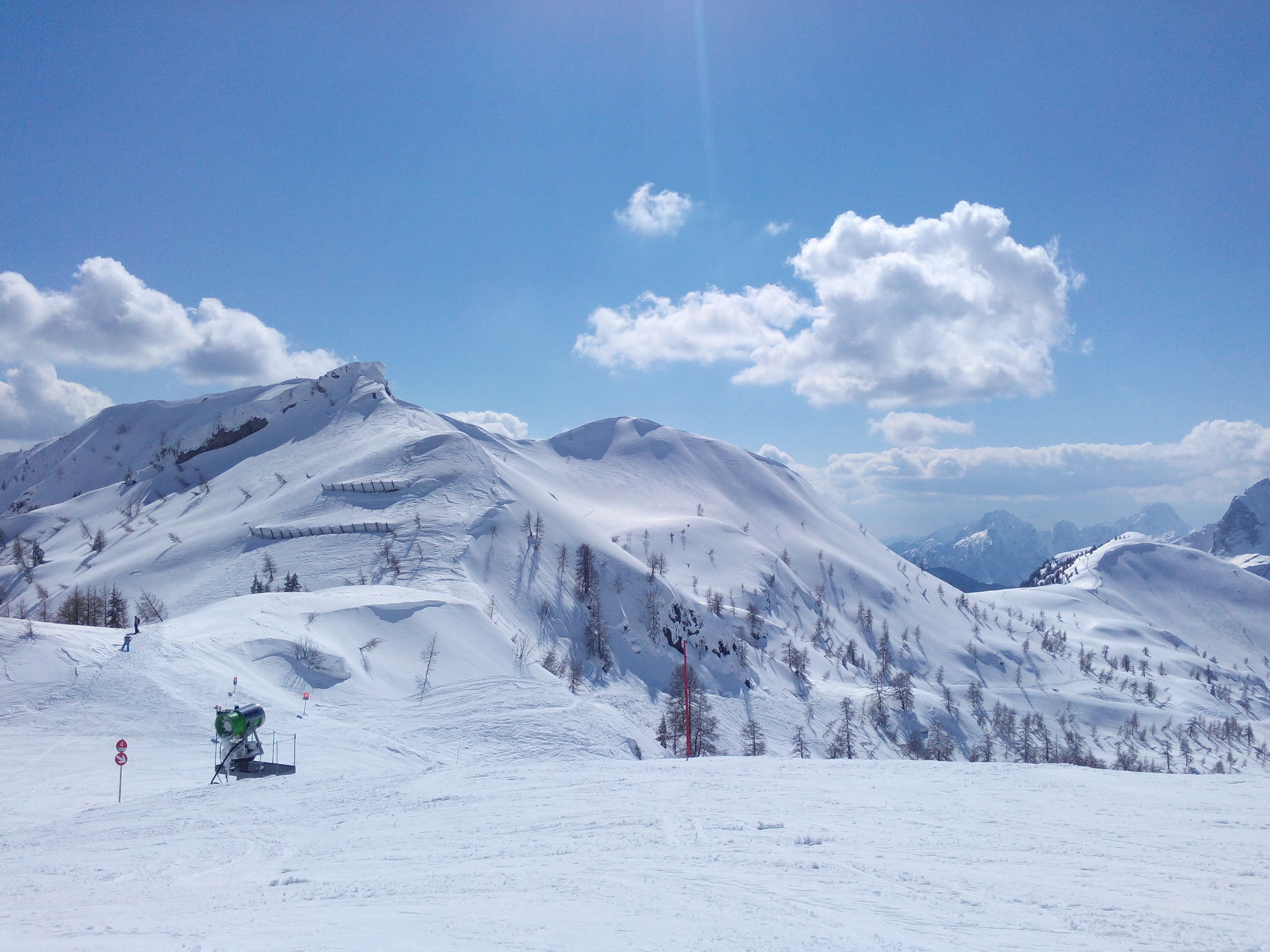 Eine verschneite Berglandschaft mit Skipisten und einer Seilbahn.