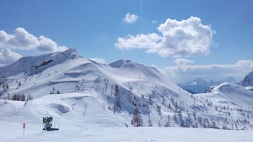Eine verschneite Berglandschaft mit Skipisten und einer Seilbahn.