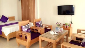 A hotel room with a bed, two wooden chairs, a small table, a TV, and a wardrobe. - Lavender Hotel (Hai Phong)