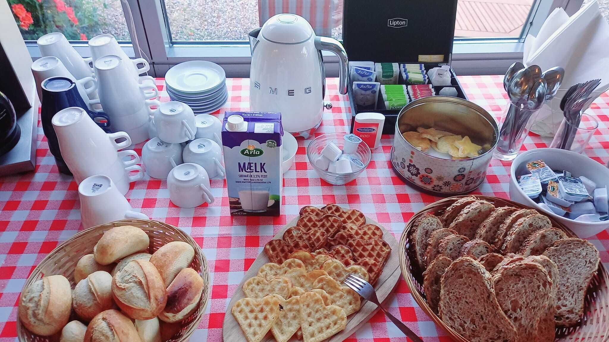 A breakfast buffet with various food items, including bread, waffles, and a milk carton.