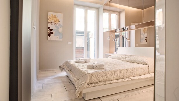 A modern bedroom with a large bed, a wardrobe, and a window with a view. - Rent In Rome - Vatican Deluxe (Rome)
