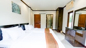 Una camera d'albergo con un letto grande, una testiera in legno, una panca in legno, una cassettiera e uno specchio grande.