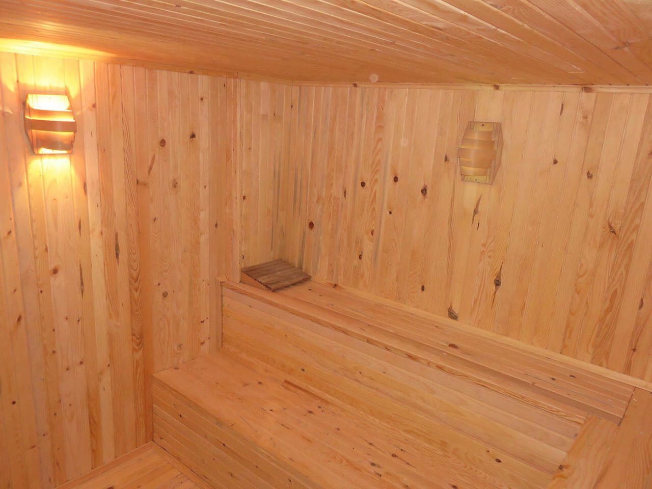 Una sauna de madera con bancos y un asiento de banco.