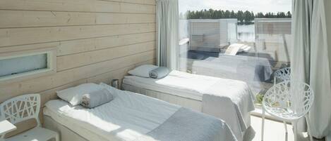 A room with two beds, a small table, and a chair.