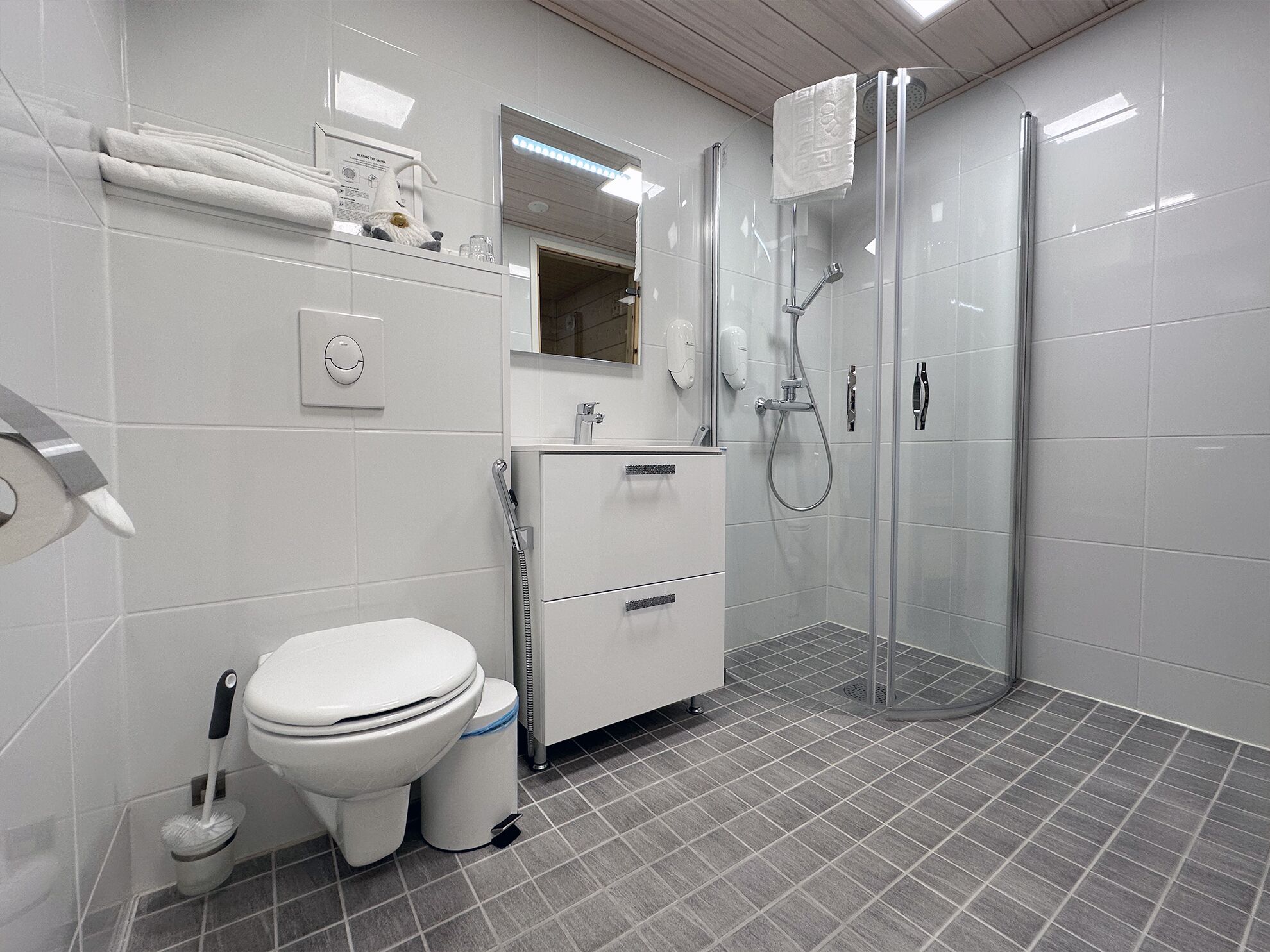 A modern bathroom with a toilet, bidet, and a glass-enclosed shower.