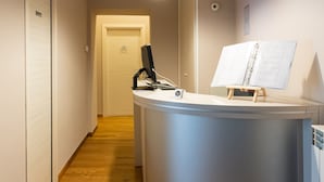 A modern reception desk with a computer, a lamp, and a framed artwork. - Duomo Hermes Relais (Naples)