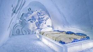 An ice hotel room with a carved ice bed, a carved ice wall, and a carved ice tree. - SnowHotel of Kemi (Kemi)