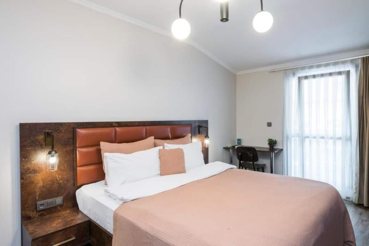 Une chambre d’hôtel avec un grand lit, un bureau et une chaise.