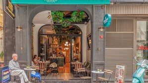 A restaurant with outdoor seating, a neon sign, and a scooter parked outside. - The Wilson Galata Hotel (Istanbul)