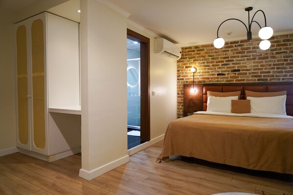 A bedroom with a brick wall, a bed with a headboard, and an air conditioning unit.
