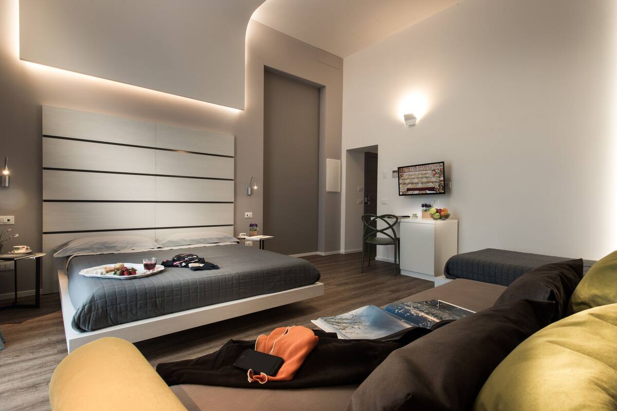 Una habitación de hotel moderna con una cama grande, un escritorio y una silla.