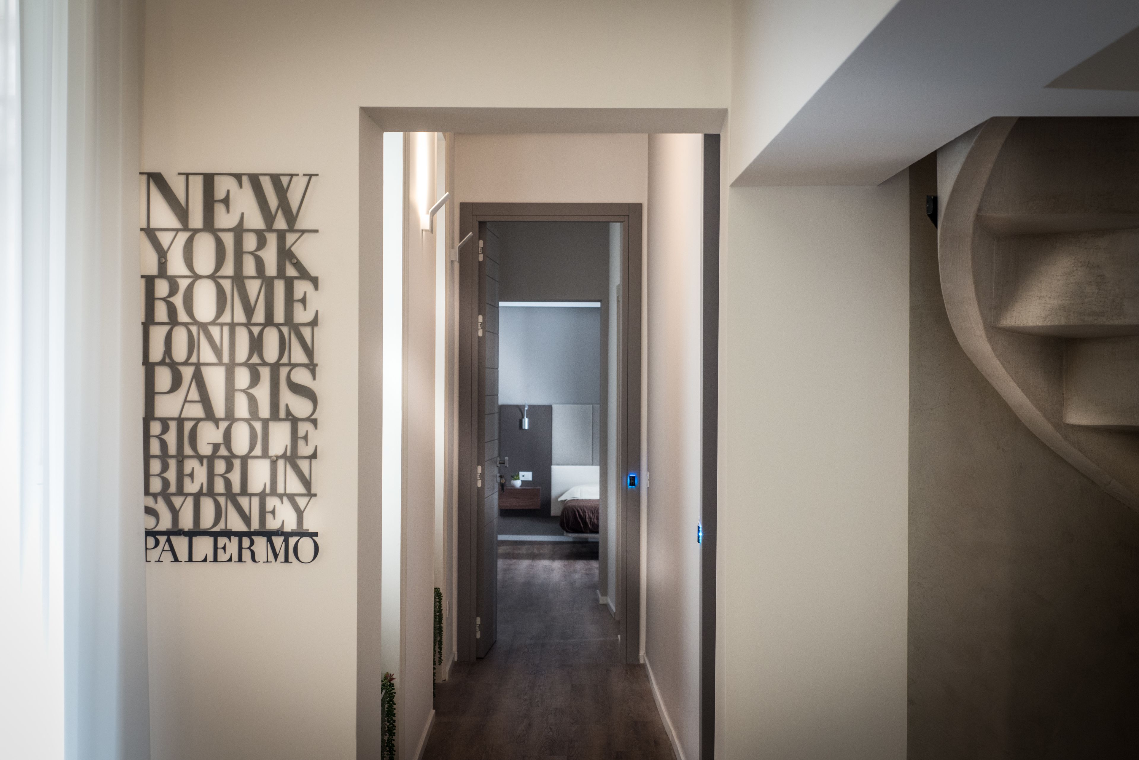 A hallway with a wall-mounted sign listing major cities.