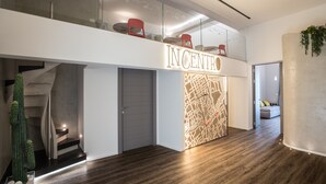 A modern interior with a staircase, a map display, and a seating area on the upper level. - B&B In Centro Palermo (Palermo)