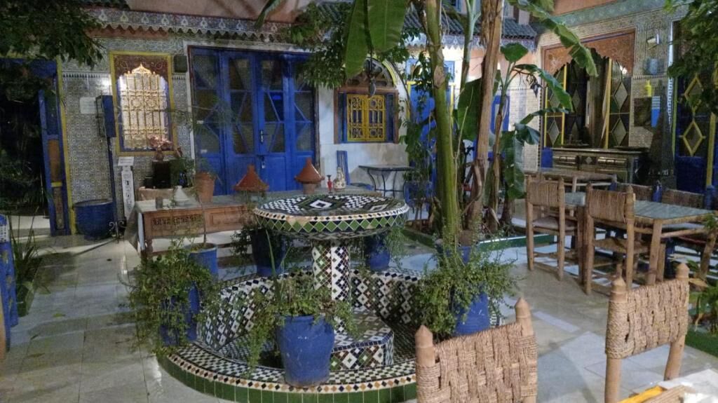 Un cortile con fontana in maiolica, zona salotto e decorazioni tradizionali.