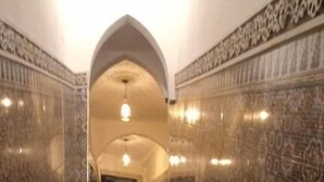 Una escalera con diseños decorativos en la pared que conduce a una puerta.