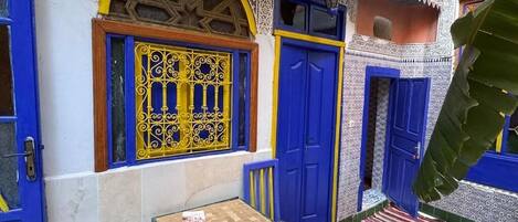 A traditional Moroccan courtyard with blue doors and intricate tile work.