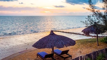 On the beach, white sand, sun loungers, beach umbrellas