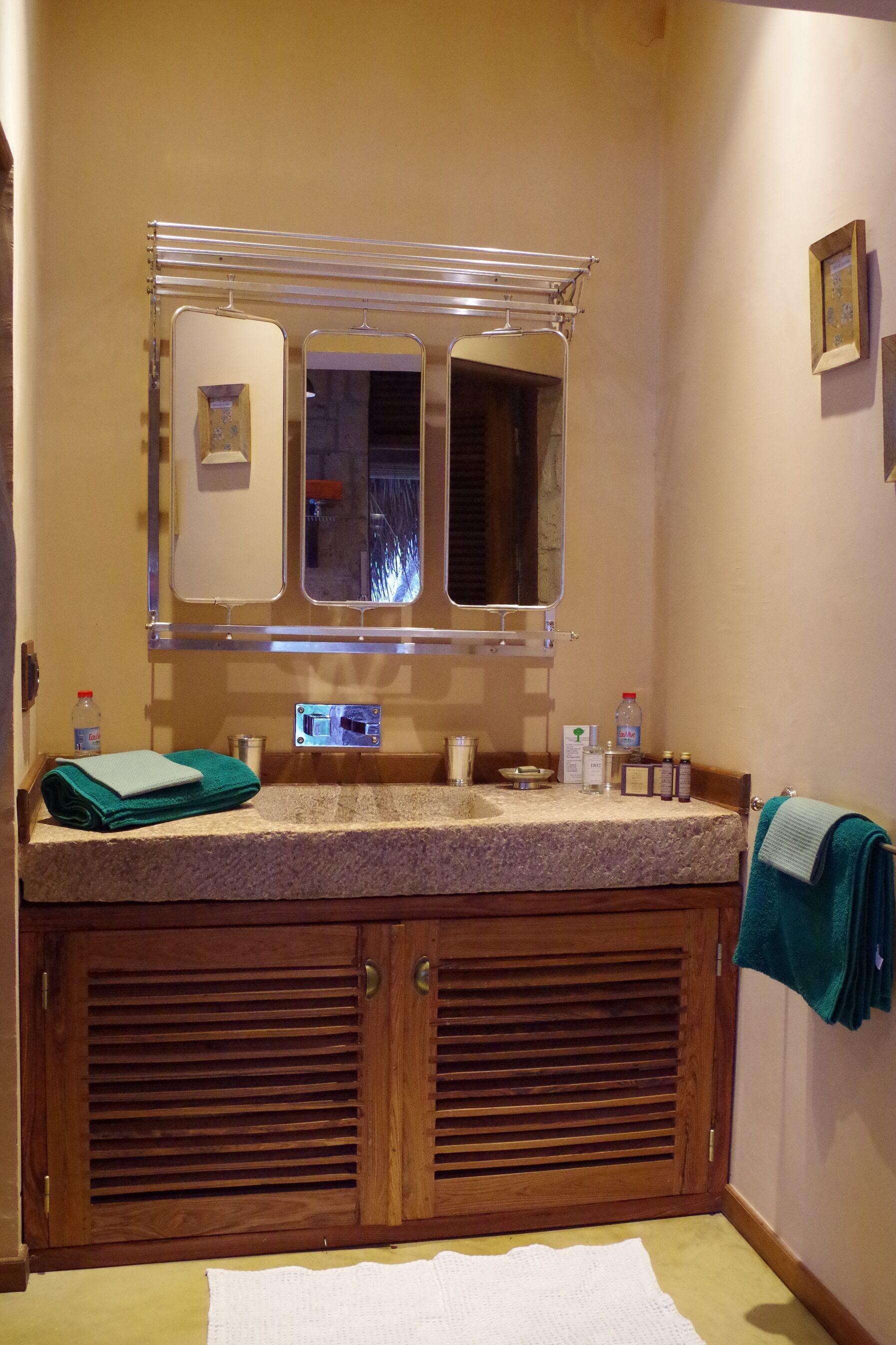 A bathroom with a wooden vanity, a mirror, and a towel rack.